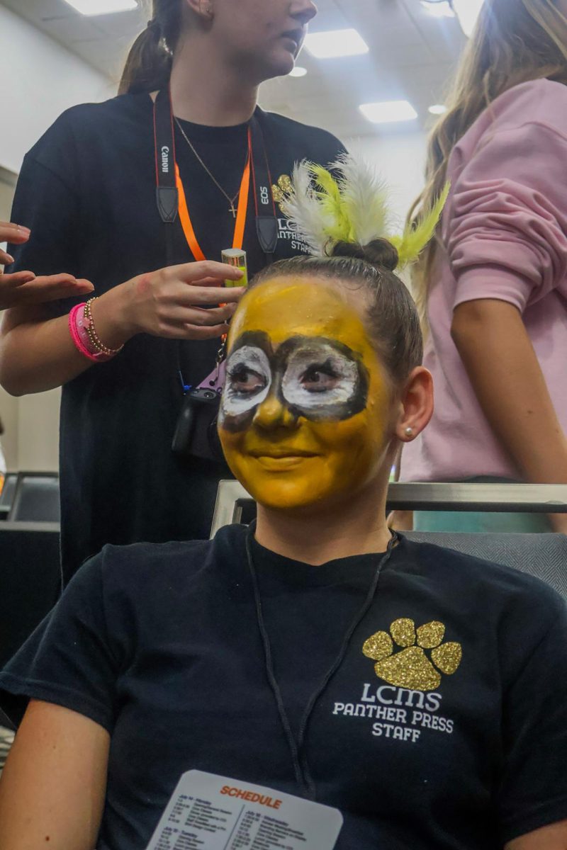 Lawton Looks - With her full face of painted makeup, seventh grader Annabelle Baurhyr sits while looking around at fellow campers. Baurhyr attended Camp Orlando and represented  Lawton Chiles Middle School, where she was able to show up and out in a display of her team’s creativity and school spirit at the event. “We wanted to show up and show out, so we picked a creative way to express our school spirit that will get us noticed.” Baurhyt said.

