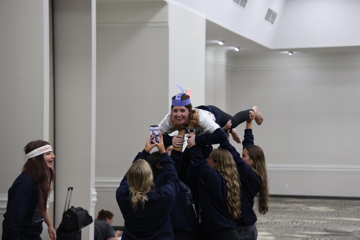 Oasis High School students film a TikTok after finishing their T-shirt design. 