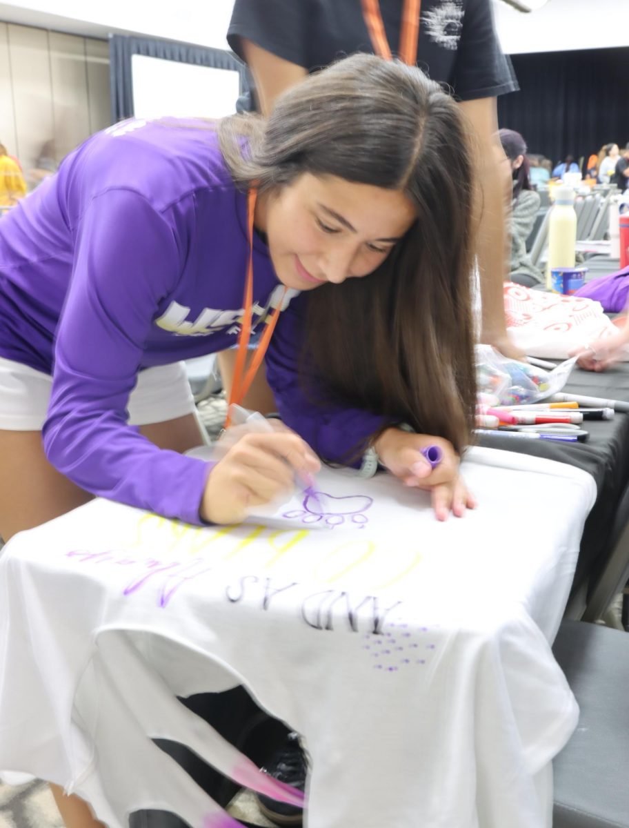 This Camp Orlando attendee works on designing their teams shirt. While she implemented her school mascot adding theming and spirit in the process.