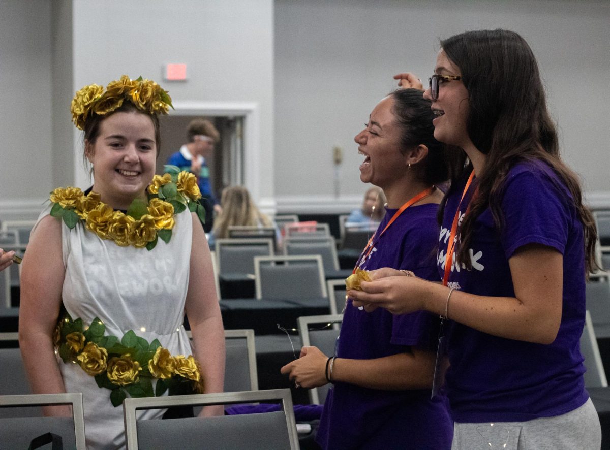 Lauren Erkes and friends laugh together for a moment while they complete Erkes’ look for the fashion show. 