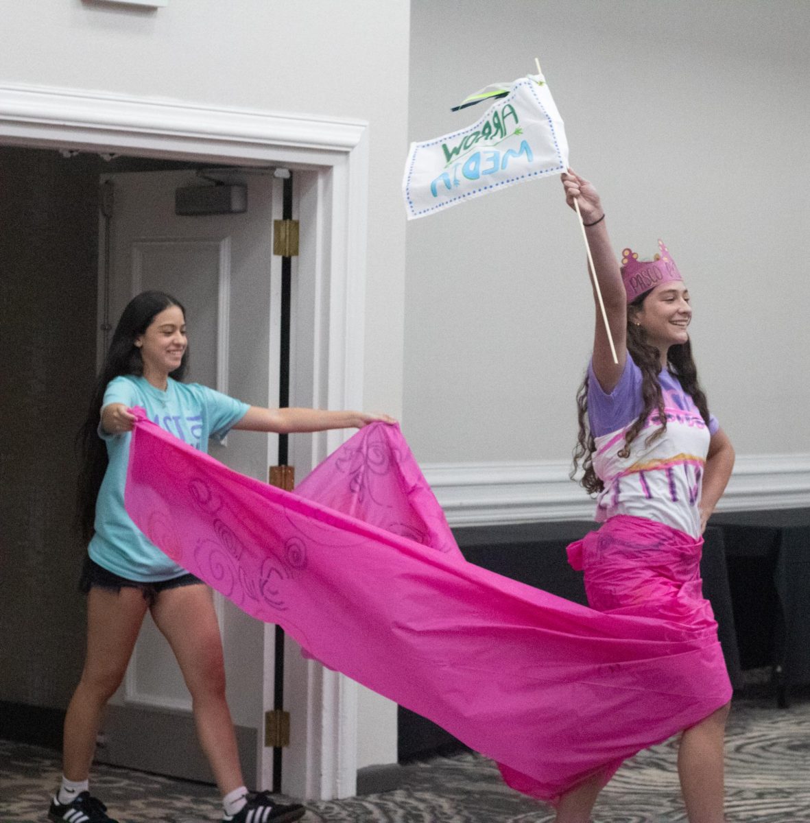 Angeline Academy students smile as they walk the runway gracefully, as one carries junior Tessa Sevelius' elegant pink train.