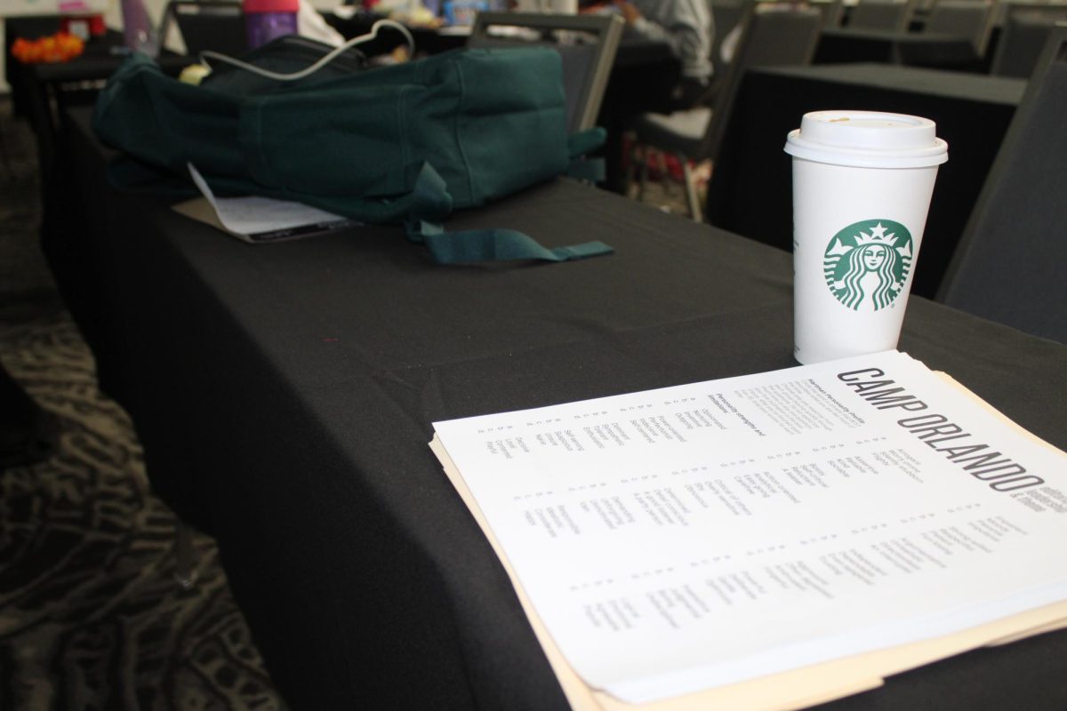 A camper's bag and Starbucks drink sit next to a Camp Orlando schedule. packed with activities.