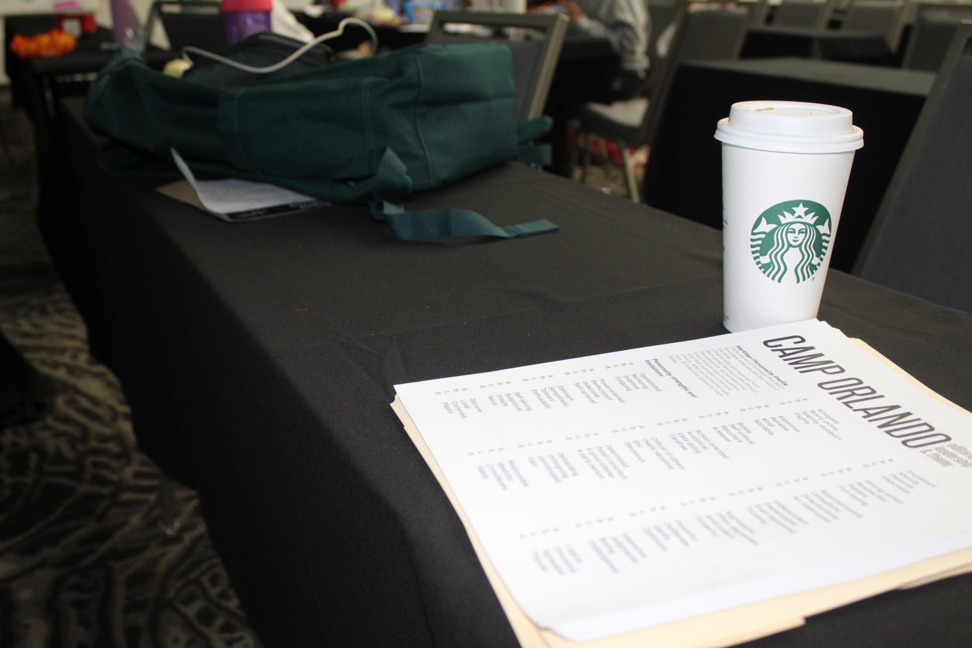 A camper's bag and Starbucks drink sit next to a Camp Orlando schedule. packed with activities.